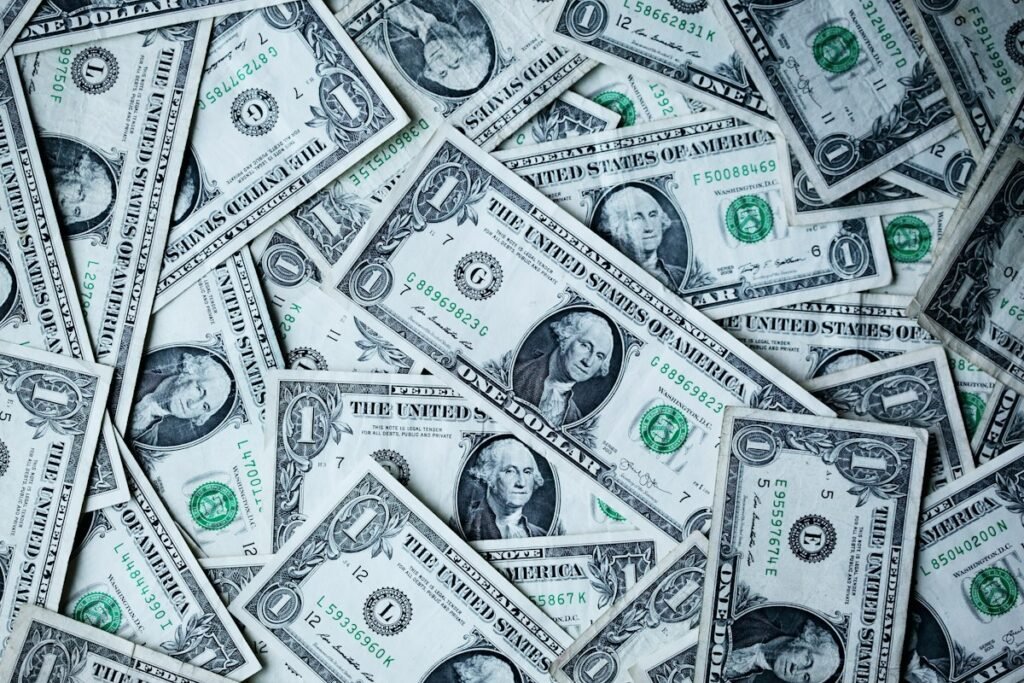 Hands holding money and a plant for savings – how to build an emergency fund