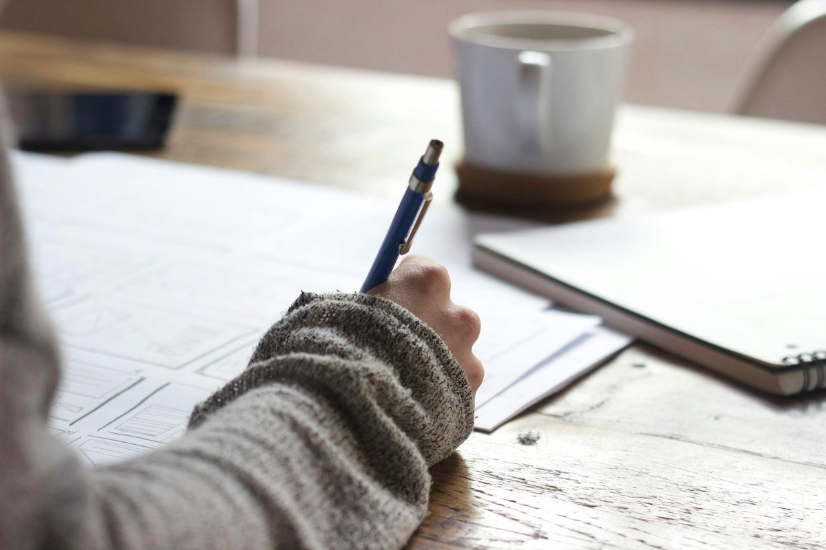Student writing study notes in a notebook – effective study techniques
